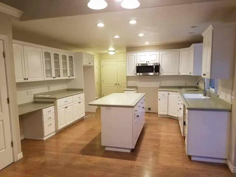 Kitchen with white painted cabinets, glass-front uppers and a white painted center island